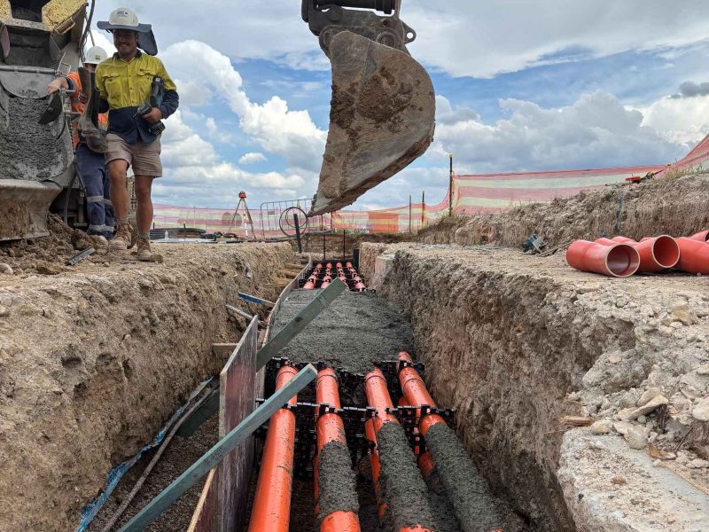 Concrete encasement poured over HV and LV conduits in an open trench